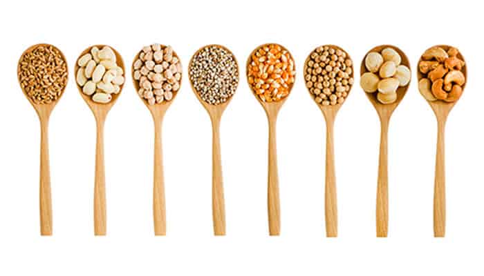wooden spoons with different types of grains and seeds