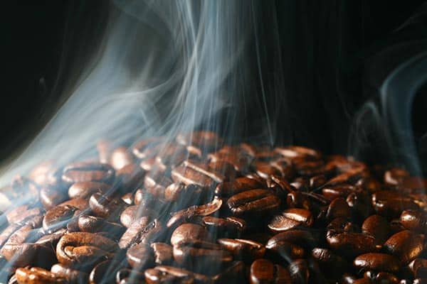 coffee beans with smoke coming out.